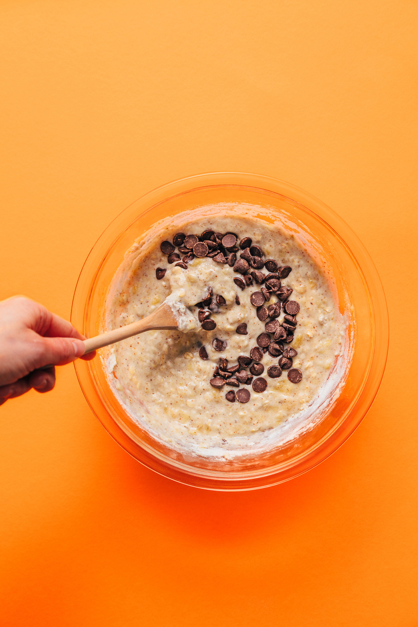 Using a wooden spoon to stir batter for our Chocolate Chip Banana Bread Waffles recipe
