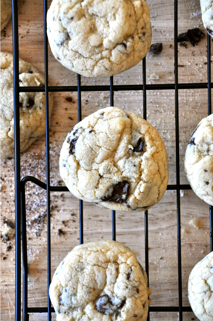 Fluffy Chocolate Chip Cookies with Candied Ginger! Cutting board and cooling rack with a batch of our Candied Ginger & Sea Salt Chocolate Chip Cookies recipe