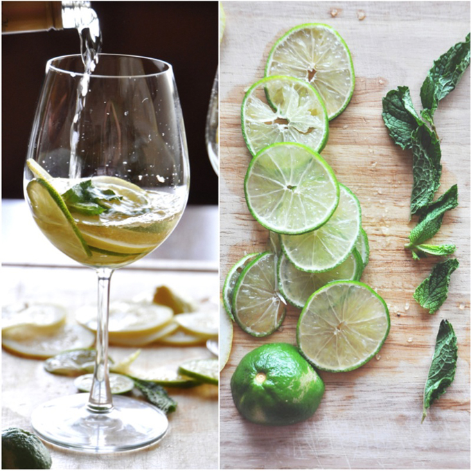 Pouring white wine into a glass of citrus and mint for a simple homemade Sangria recipe