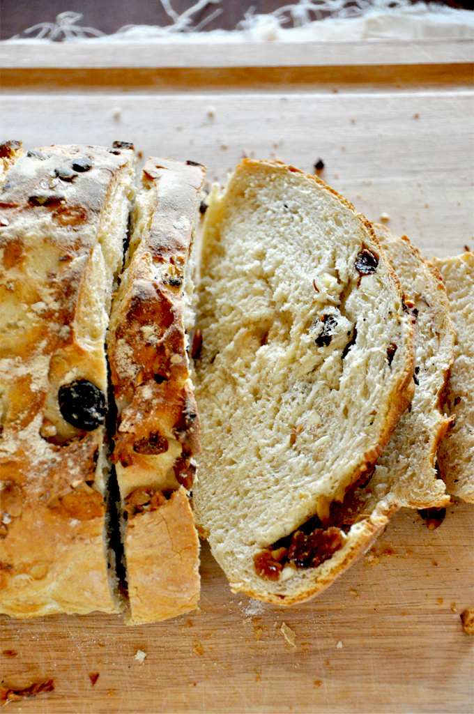 Muesli Bread! - by the Minimalist Baker Partially sliced loaf of homemade Muesli Bread on a cutting board