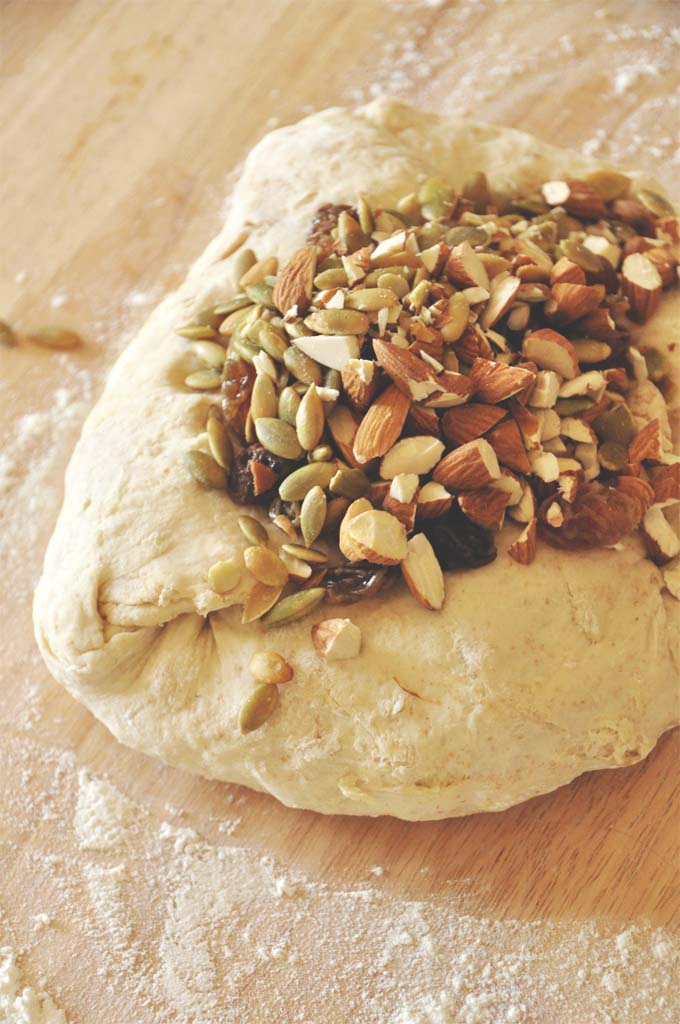 Muesli Bread Loaf of unbaked Muesli Bread with almonds, pumpkin seeds, and raisins on top