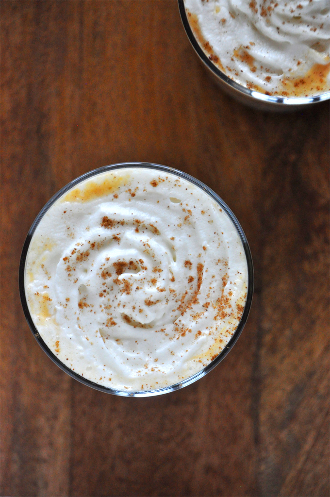 Boozy Pumpkin White Hot Chocolate! Minimalist Baker Top down shot of a whipped cream spiral topped with cinnamon on top of a Boozy Pumpkin White Hot Chocolate