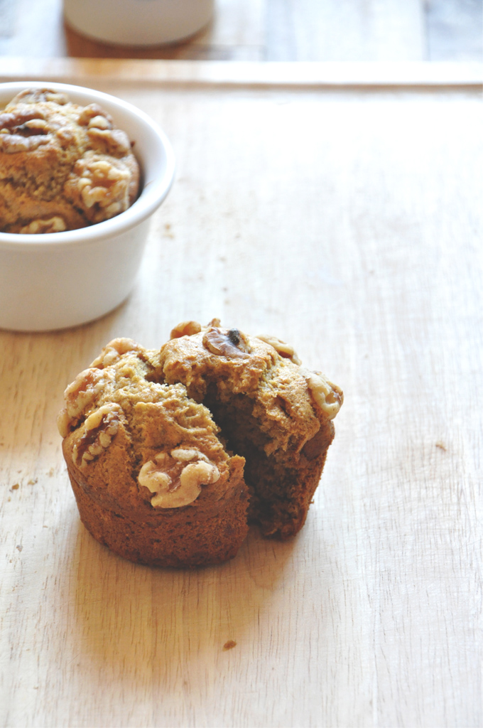 Coffeehouse Vegan Banana Nut Muffins for 2 Sliced open Vegan Banana Nut Muffin with the other muffin in the batch behind it