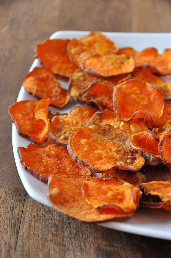 Plate of homemade sweet potato chips sliced with a knife