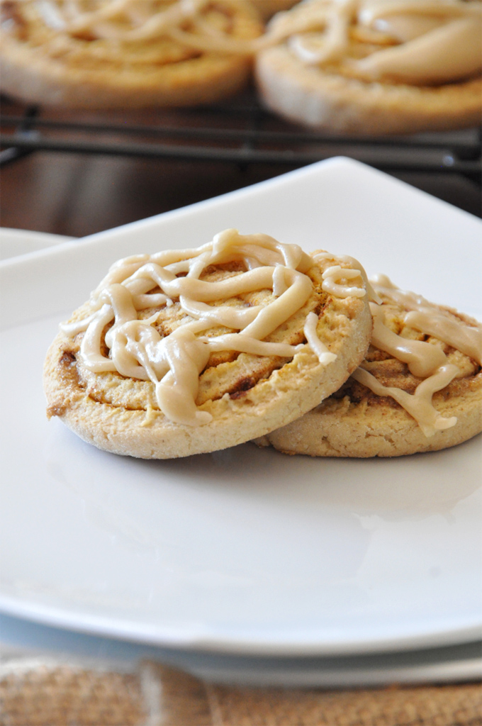 Plate with two Pumpkin Cinnamon Roll Cookies drizzled with icing