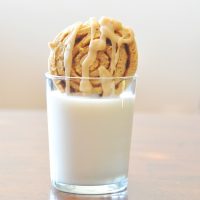 Dipping a Pumpkin Cinnamon Roll Cookie into a glass of dairy-free milk