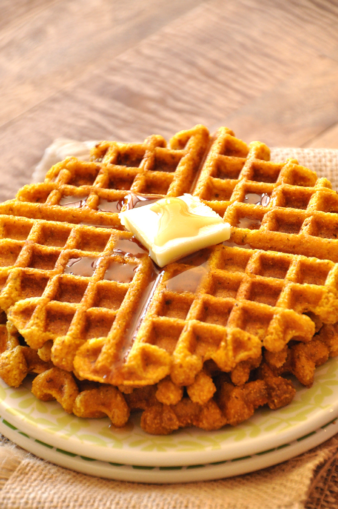Stack of Vegan Pumpkin Cornbread Waffles with syrup and vegan butter on top