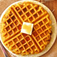 Top down shot of a Vegan Pumpkin Cornbread Waffle topped with vegan butter and syrup