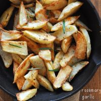 Bowl filled with homemade Crispy Baked Rosemary Garlic Fries