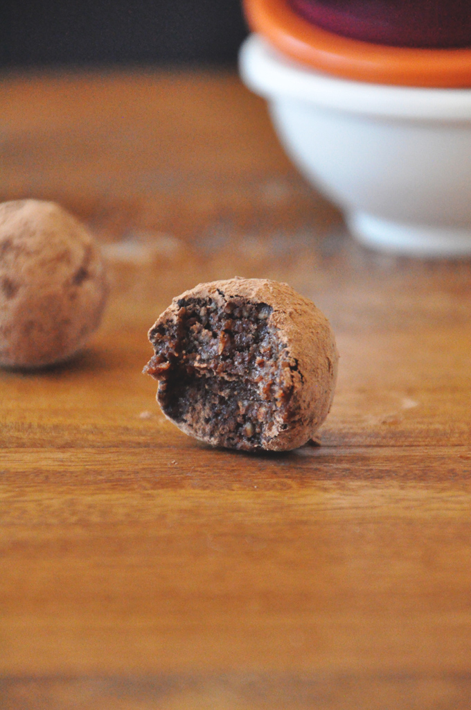 Half eaten truffle made with almonds, dates, cocoa powder, and spices