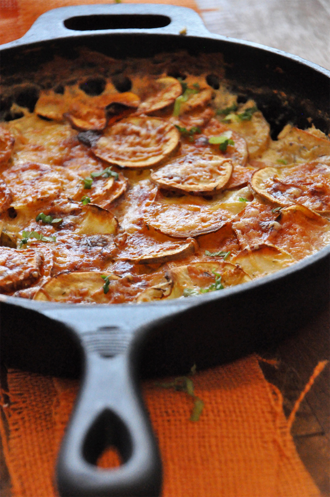 Pan of delicious Sweet Potato Parmesan Gratin sprinkled with fresh parsley