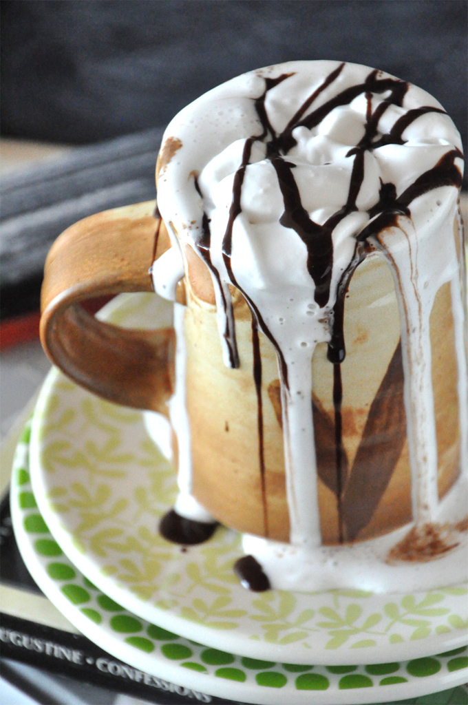 Mug overflowing with homemade Mexican Hot Chocolate and Coconut Whipped Cream
