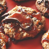 Batch of Gluten-Free Bourbon Caramel Samoa Cookies on a red background