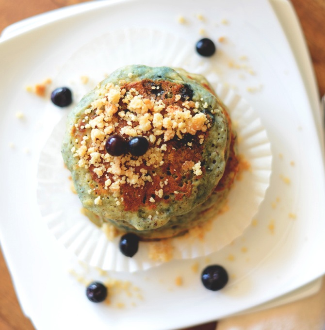 Top down shot of a stack of Vegan Blueberry Muffin Pancakes with fresh blueberries