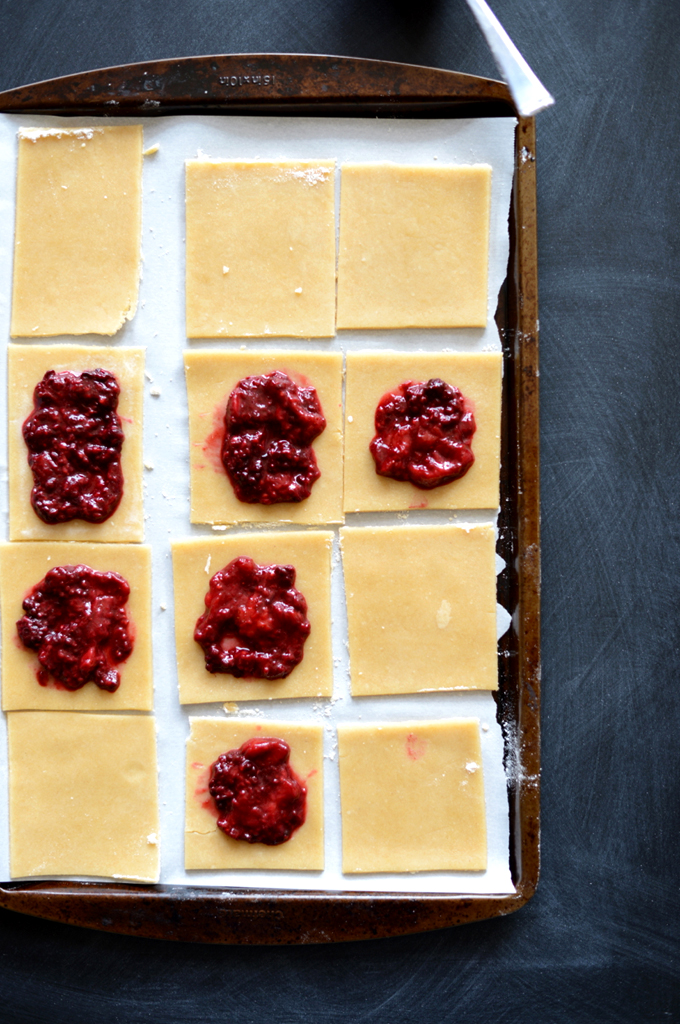Baking sheet with squares of homemade Pop Tart dough with dollops of mixed berry compote on top