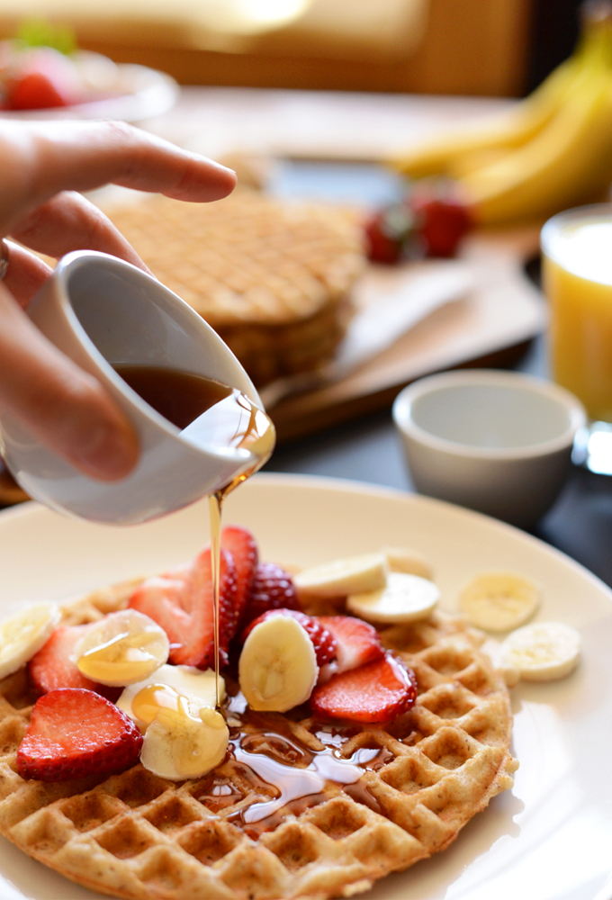 Pouring syrup onto a Crispy Gluten-Free Vegan Oatmeal Waffle