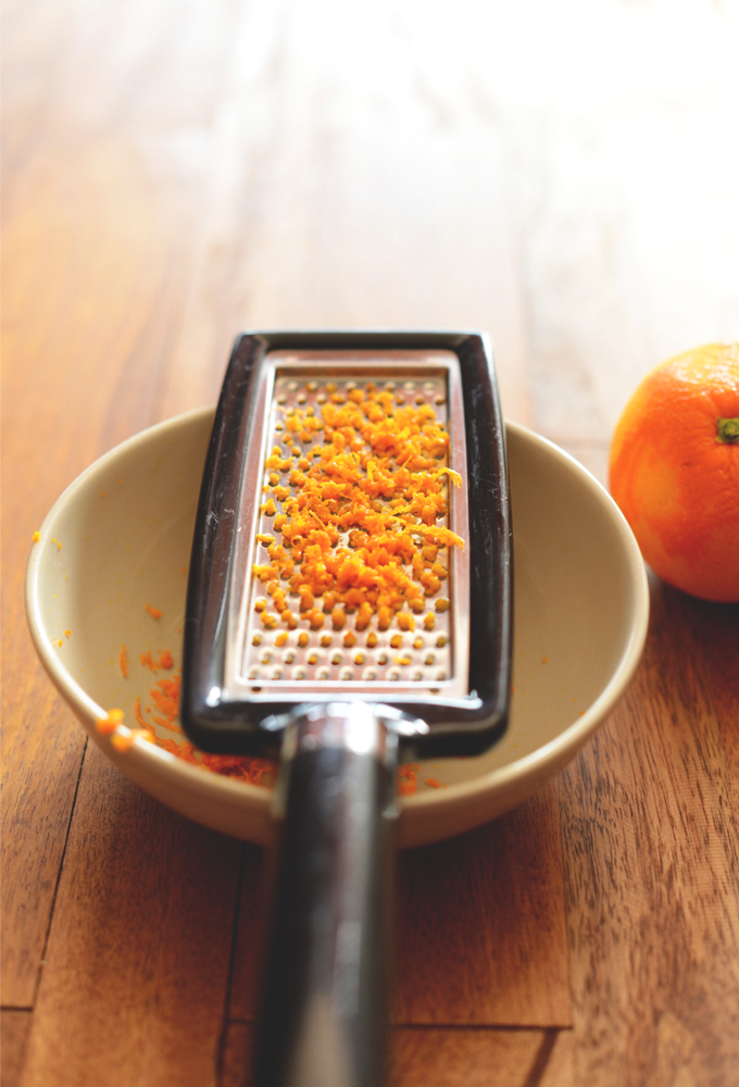 Orange zest grated over a bowl for making simple homemade jam