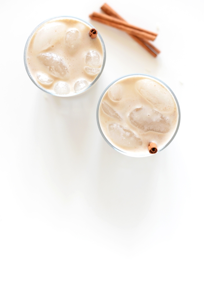Two glasses of Date Sweetened Horchata with cinnamon sticks as straws
