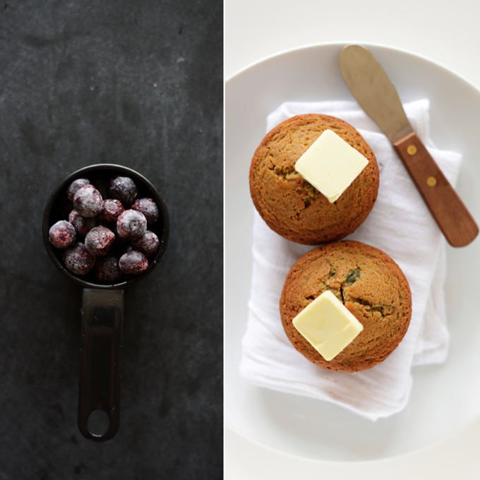 Measuring cup of blueberries and plate with a batch of our Blueberry Muffins for 2 recipe