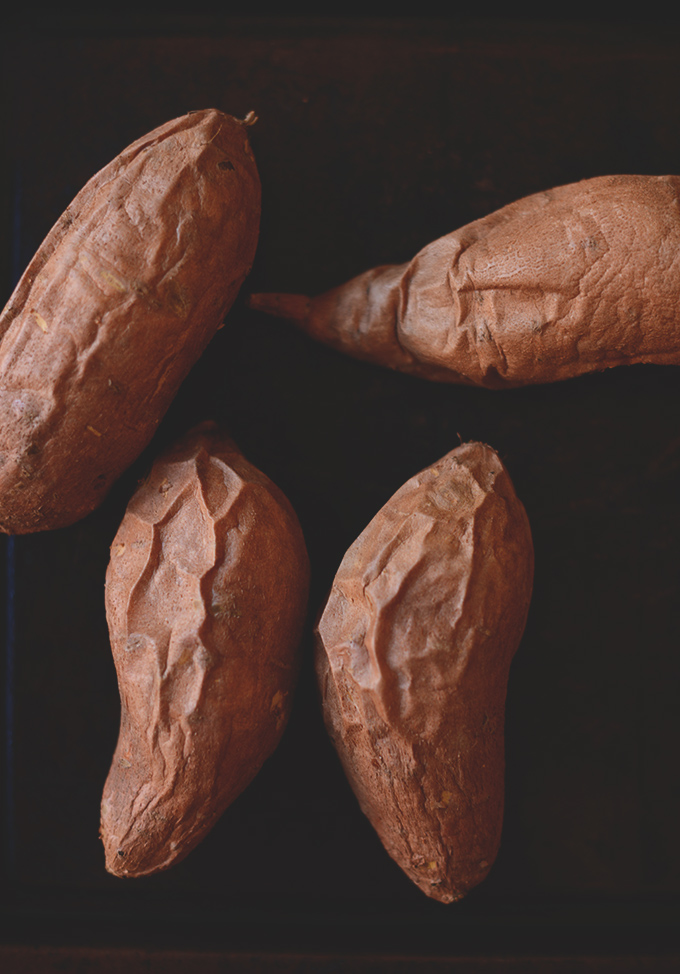 Whole baked sweet potatoes for on a baking sheet