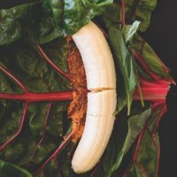 Fresh basil, banana, and peanut butter on a chard leaf
