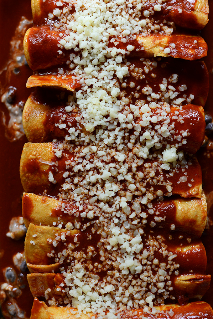Batch of vegetarian Black Bean Green Chili Enchiladas sprinkled with manchego cheese