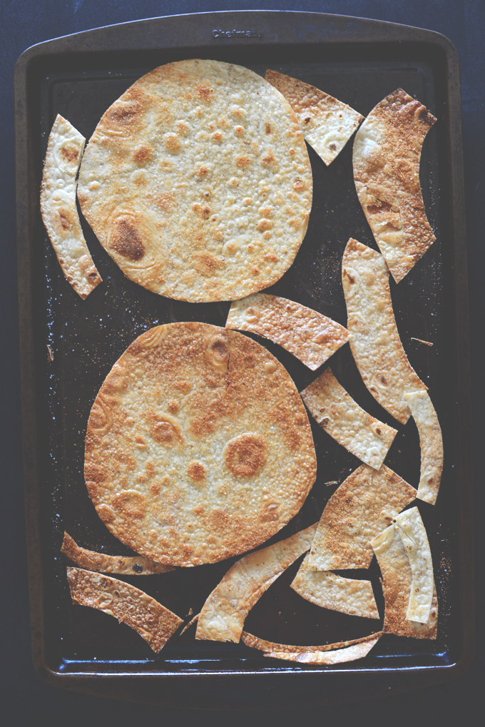 Baking sheet with lightly browned gluten-free tortillas for making tostadas