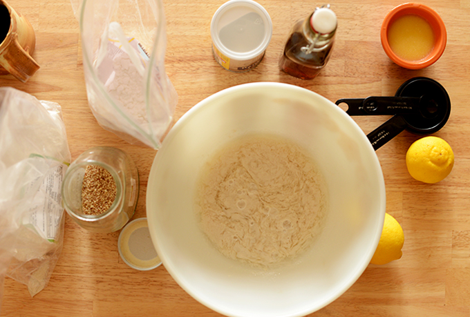 Mixing bowl with dry ingredients surrounded by other ingredients for making waffles