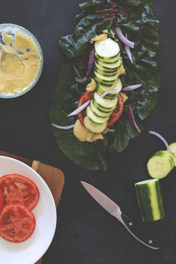 Rainbow chard leaf topped with hummus and fresh vegetables
