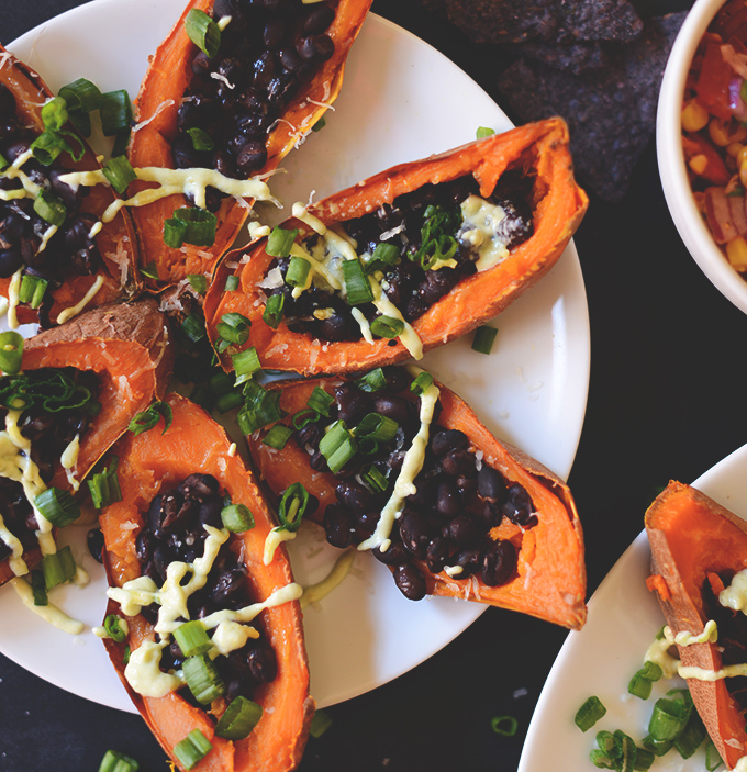 Plate of Loaded Sweet Potato Black Bean Boats drizzled with avocado crema
