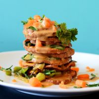 Side view of a stack of Thai Sweet Potatoes drizzled with Peanut Sauce