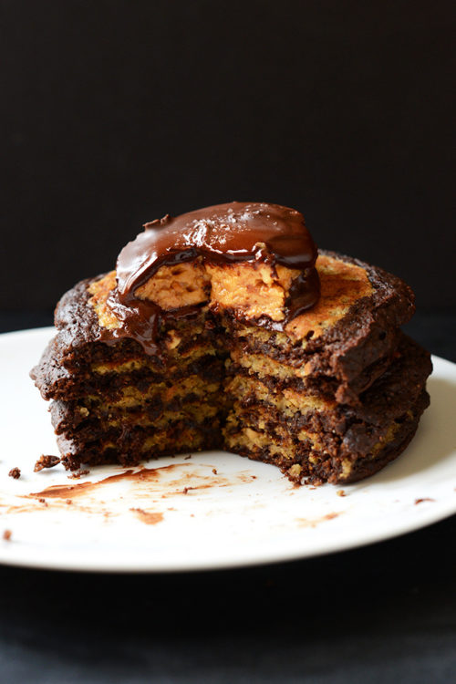Stack of Chocolate Peanut Butter Cup Pancakes with a big slice removed