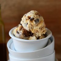 Stack of bowls with the top one filled with scoops of homemade Vegan Snickers Ice Cream