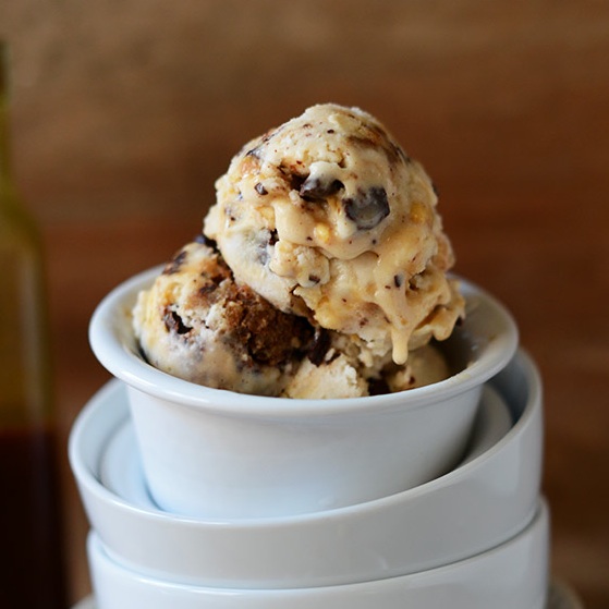 Stack of bowls with the top one filled with scoops of homemade Vegan Snickers Ice Cream