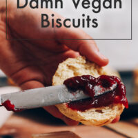 Spreading jam onto a vegan biscuit