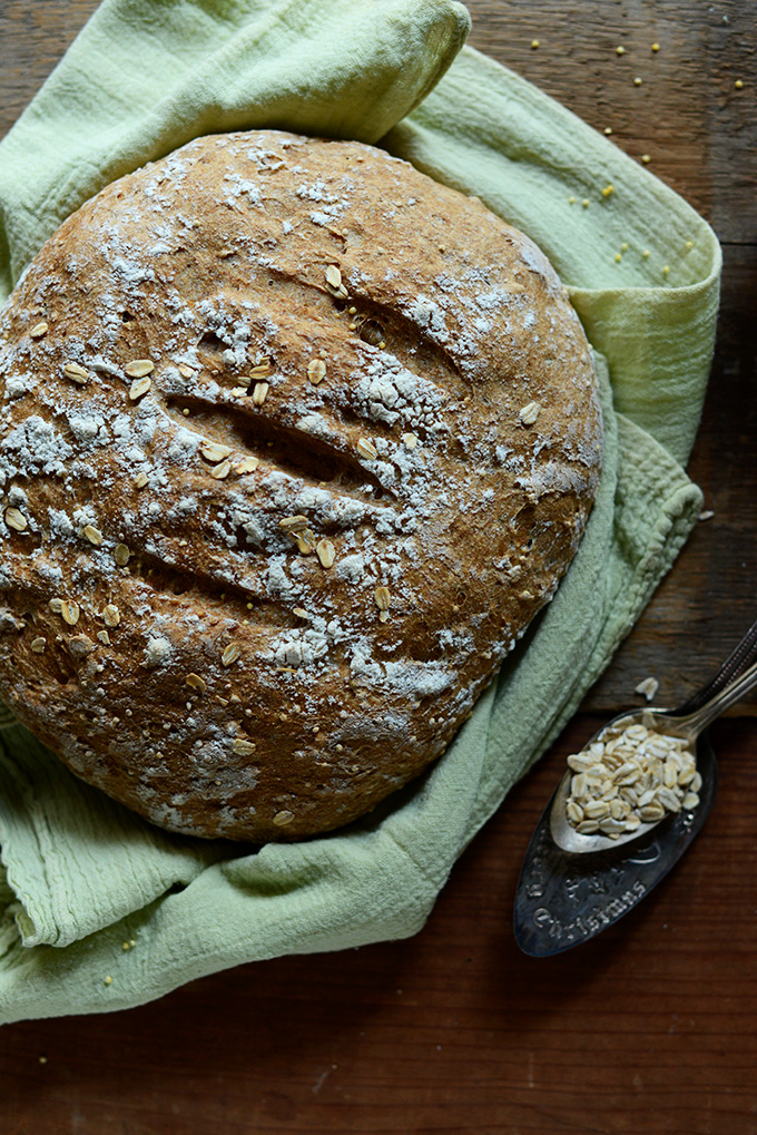 Loaf of homemade 7-Ingredient Grainy Bread on a cutting board