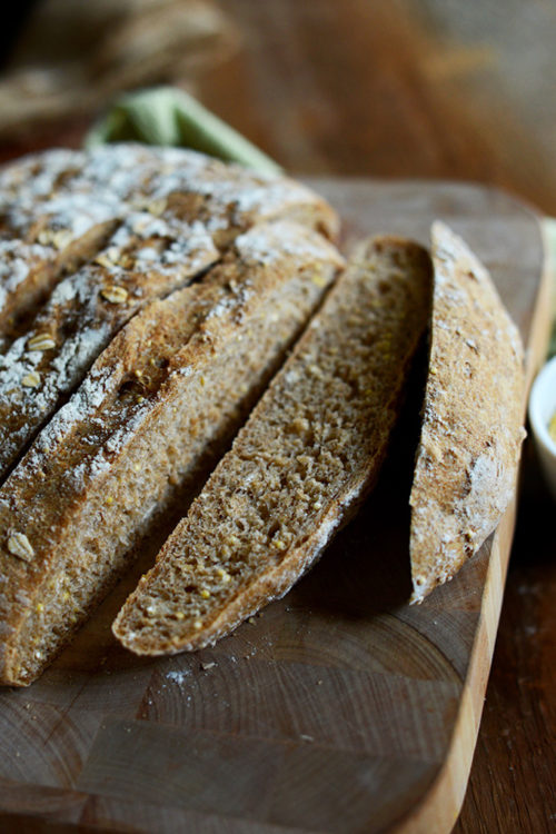 Cutting board with a loaf of Grainy Wheat Bread