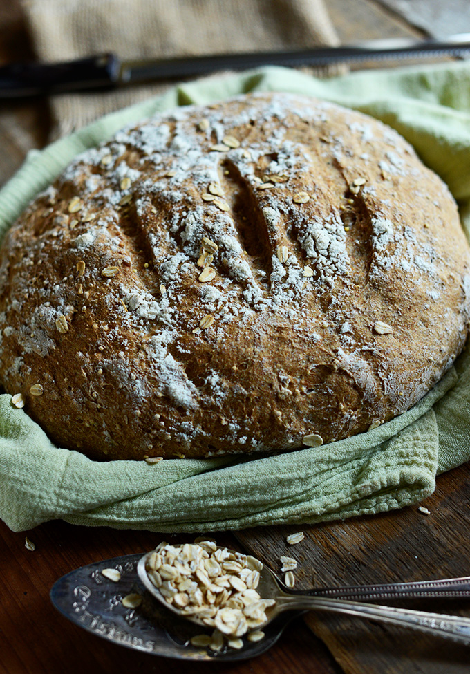 Loaf of Homemade Wheat Bread resting on a kitchen towel