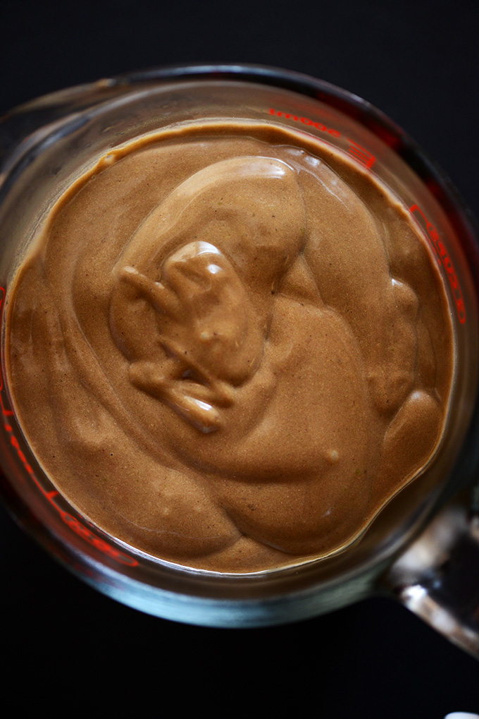 Measuring glass filled with a batch of our Creamy Avocado Chocolate Milkshake recipe