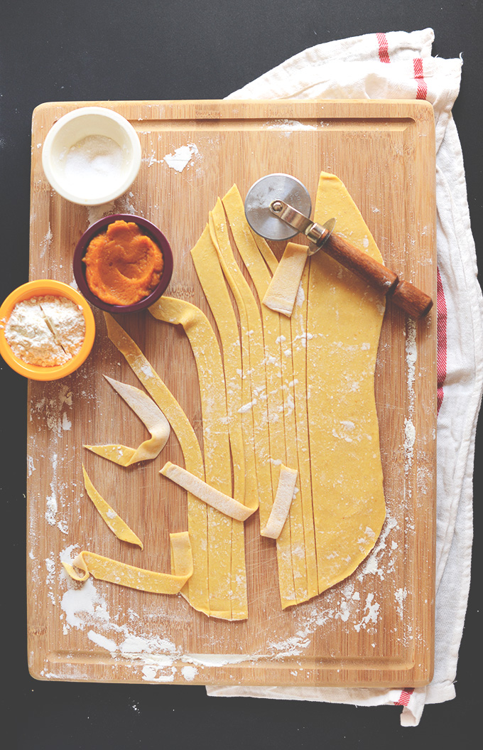 Using a pizza cutter to cut strips of homemade Pumpkin Pasta