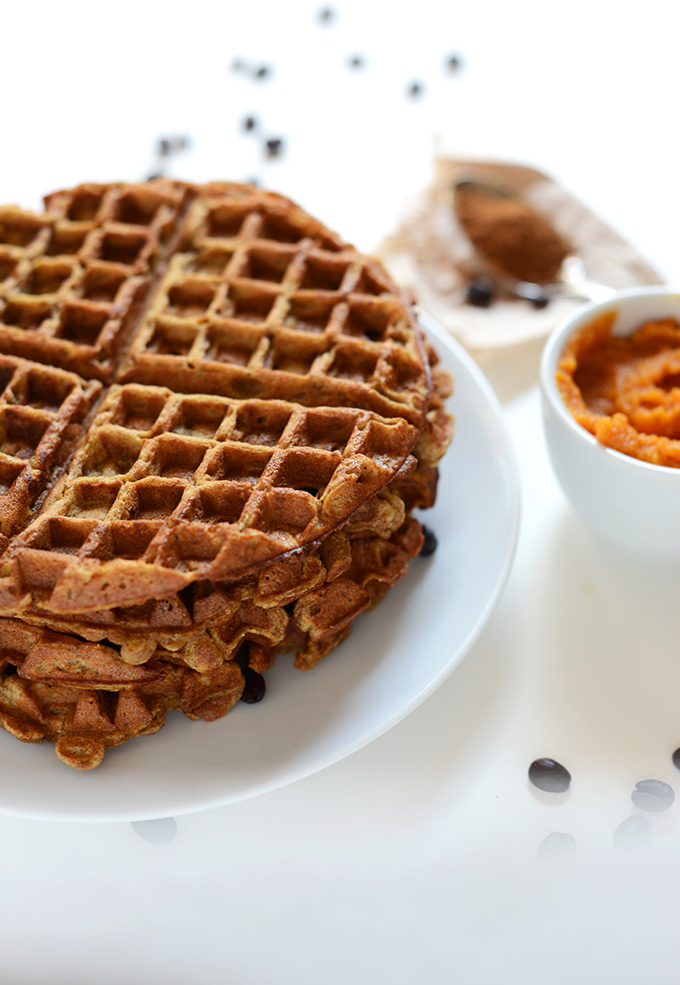 Stack of Pumpkin Spice Waffles alongside a bowl of puree pumpkin