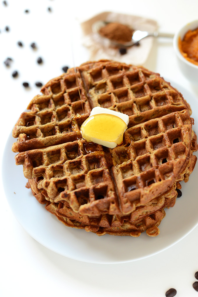 Drizzling Vegan Pumpkin Spice Waffles with maple syrup