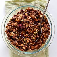 Spoon in a glass bowl filled with Sweet Potato Granola