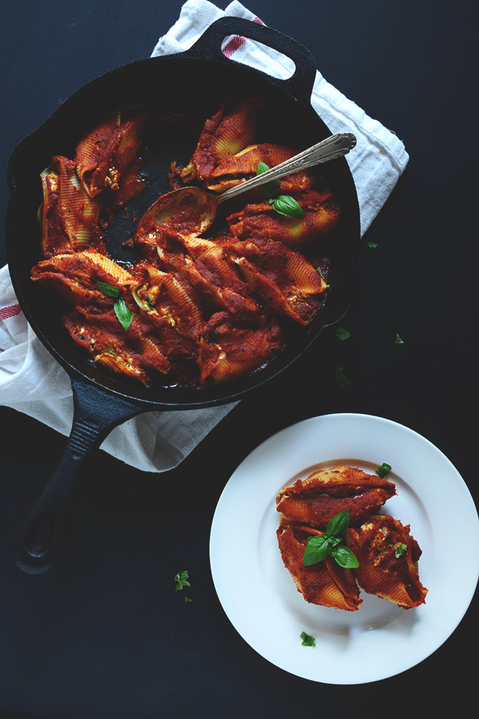 Plate and skillet of Tofu Eggplant Stuffed Shells with fresh basil