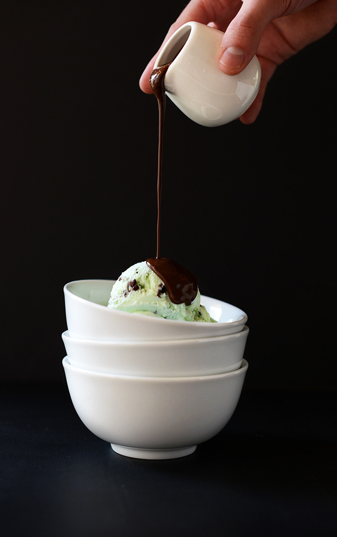 Pouring Vegan Kahlua Hot Fudge onto a bowl of mint chip ice cream