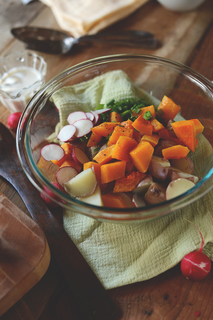 Bowl of healthy Butternut Squash Potato Salad and jar of dressing