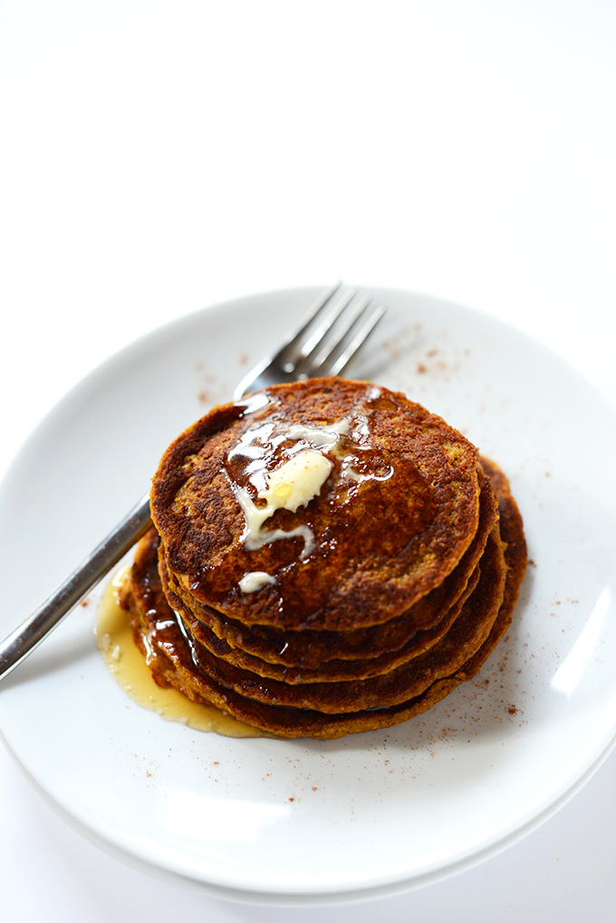 Stack of Vegan Pumpkin Spiced Pancakes topped with syrup and vegan butter