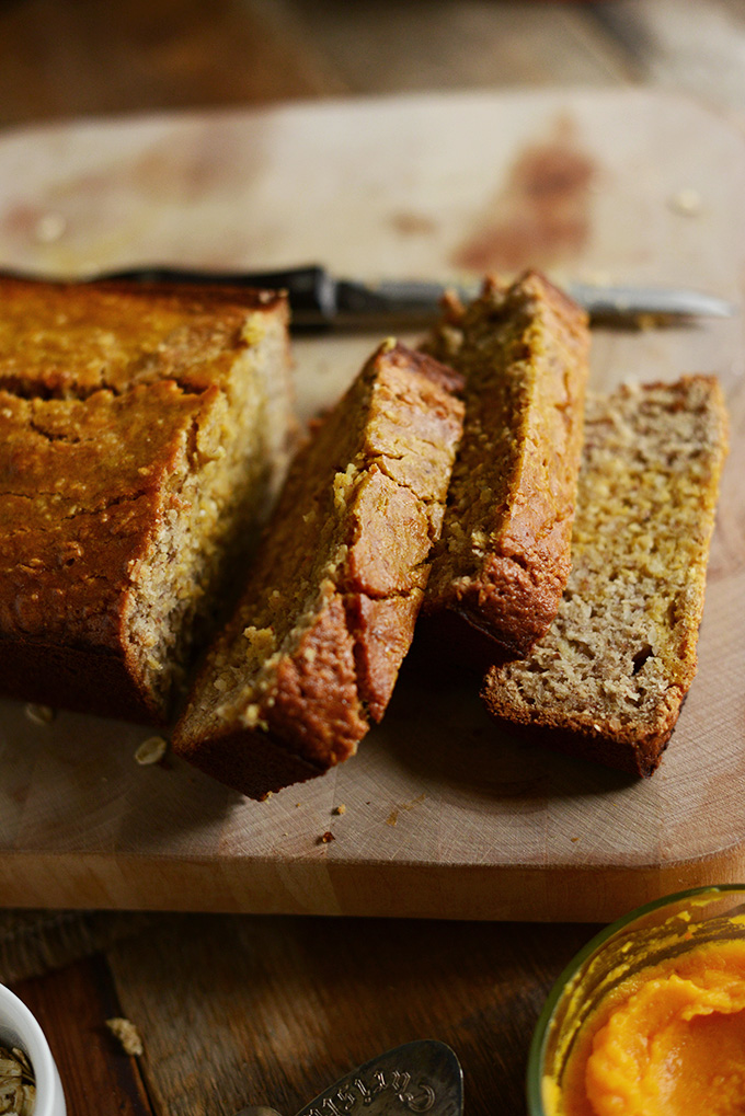Cutting board with a partially sliced loaf of Gluten-Free Squash Banana Bread
