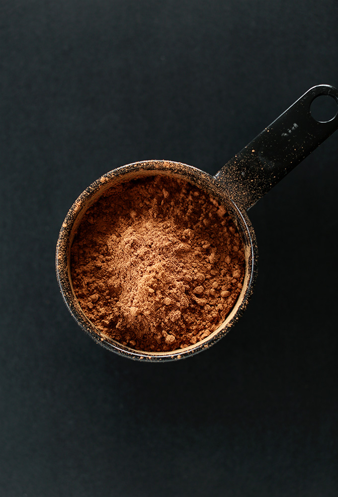 Measuring cup of cocoa powder for making gluten-free vegan brownies