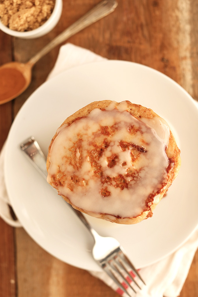 Plate with a batch of Easy Cinnamon Roll Pancakes topped with icing